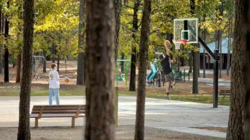 An image of people enjoying the basketball courts at the park.