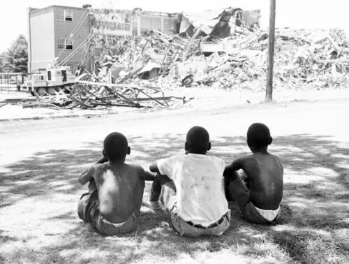 An image of students watching Second Ward High School being demolished.