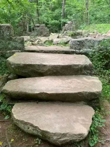 An image of steps leading to the inside of the rock house.