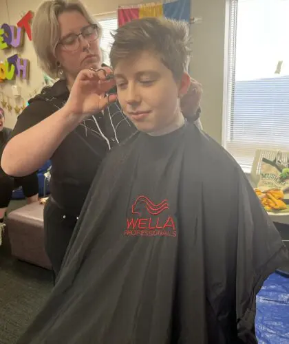 A young person getting their haircut.